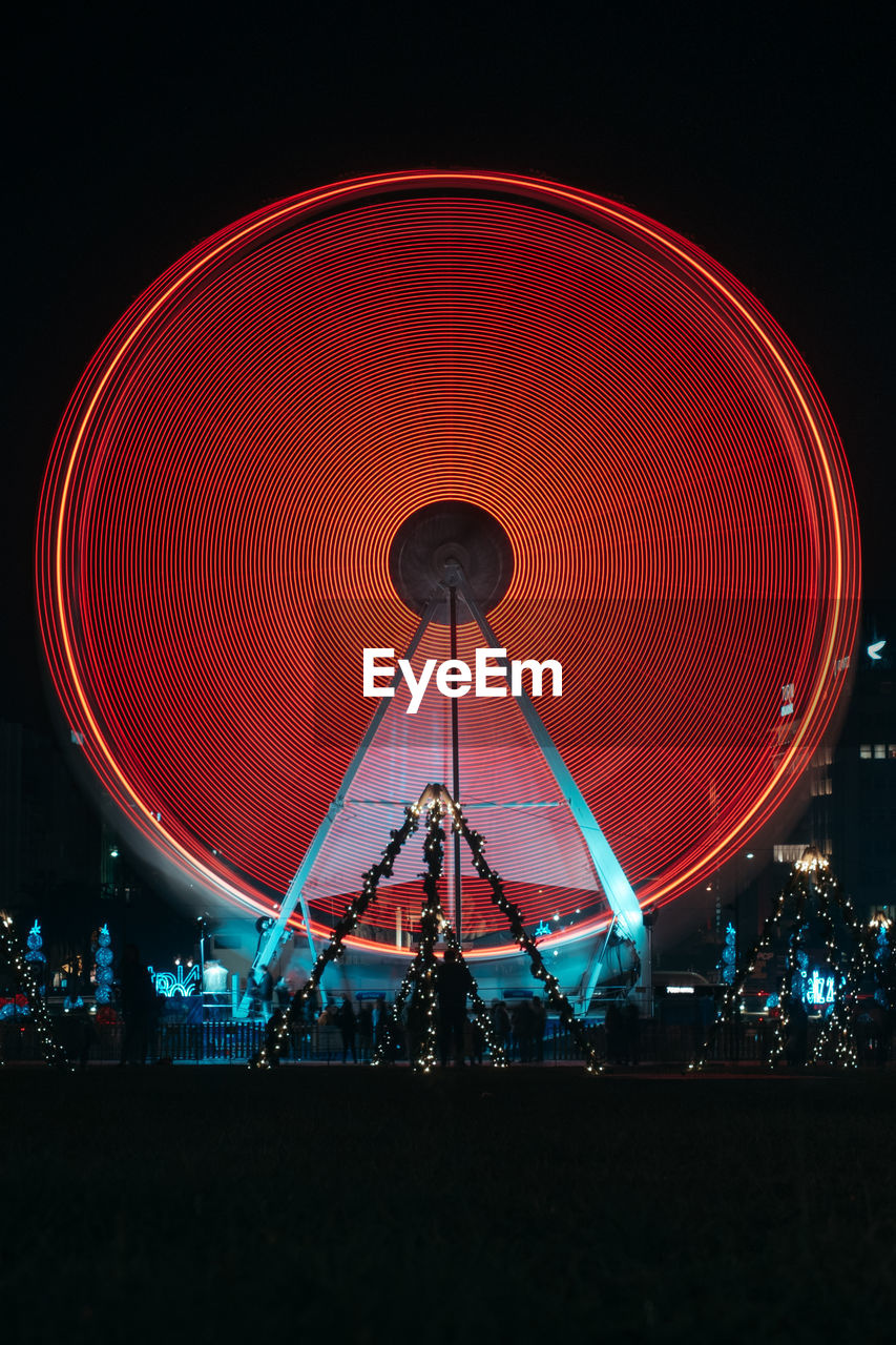 Low angle view of illuminated ferris wheel against sky at night