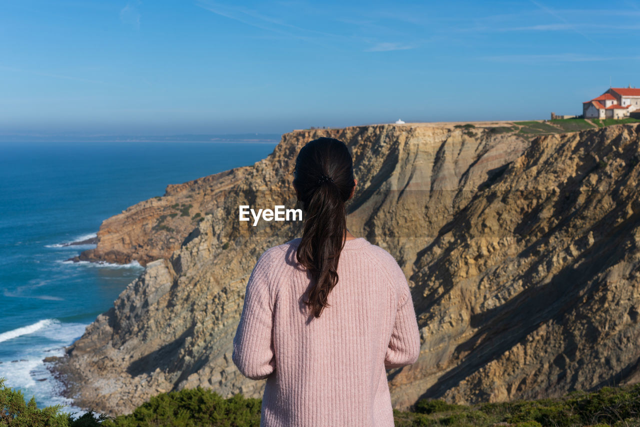 Rear view of woman looking at sea against sky