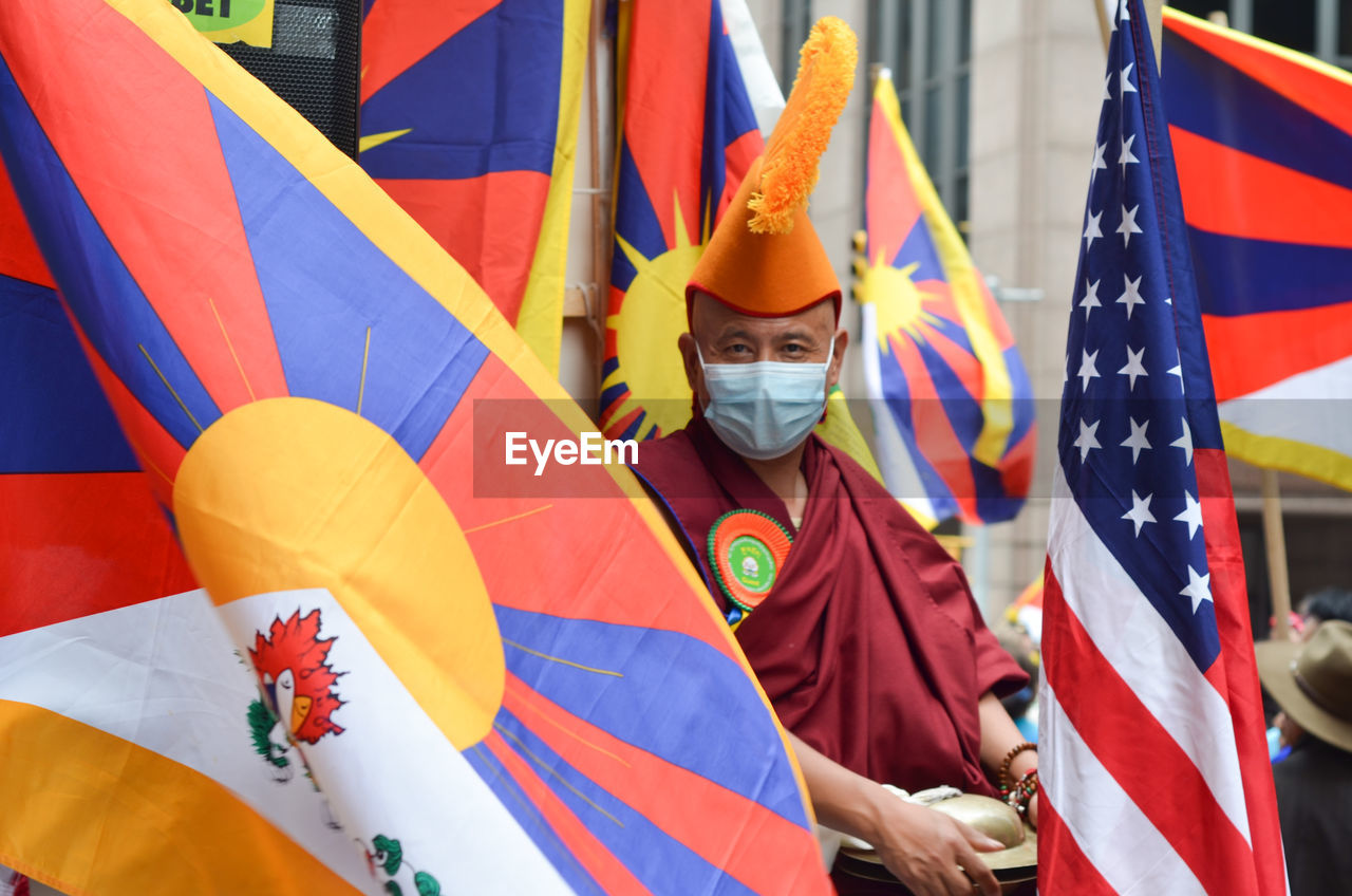 Tibetian monk is posing for a photo during the 37th annual nyc immigrants parade