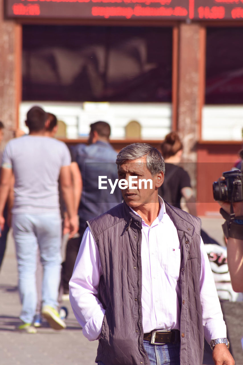 REAR VIEW OF PEOPLE LOOKING AT CAMERA IN TRADITIONAL BUILDING