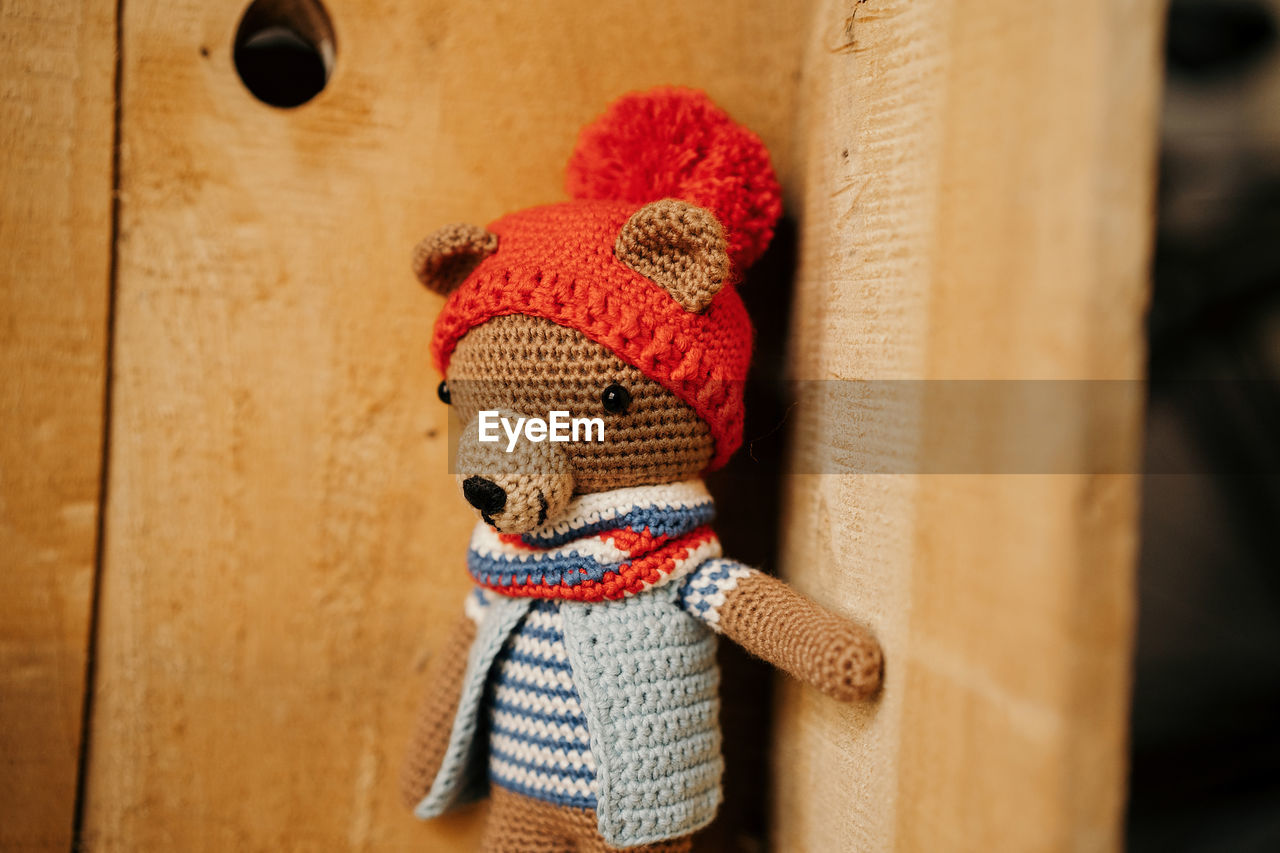 Knitted bear in wooden corner