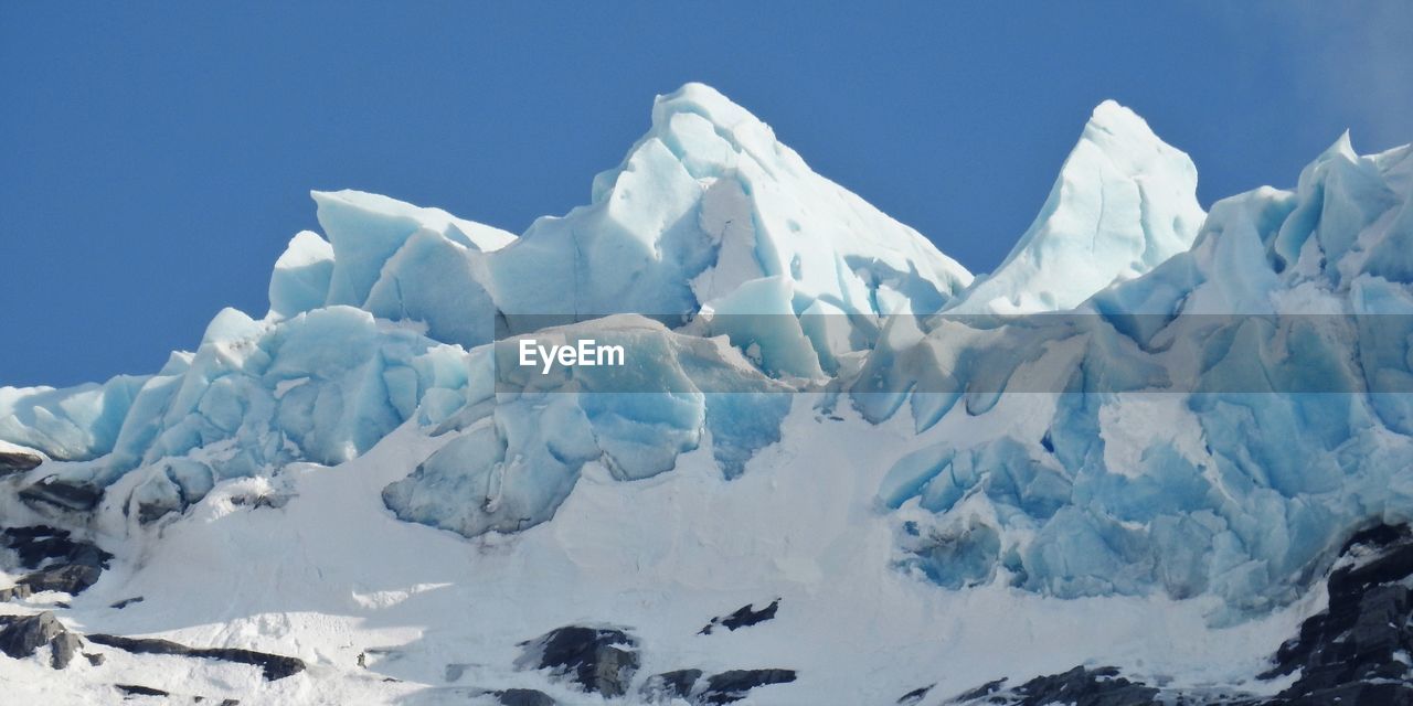 Scenic view of snowcapped mountains against clear sky