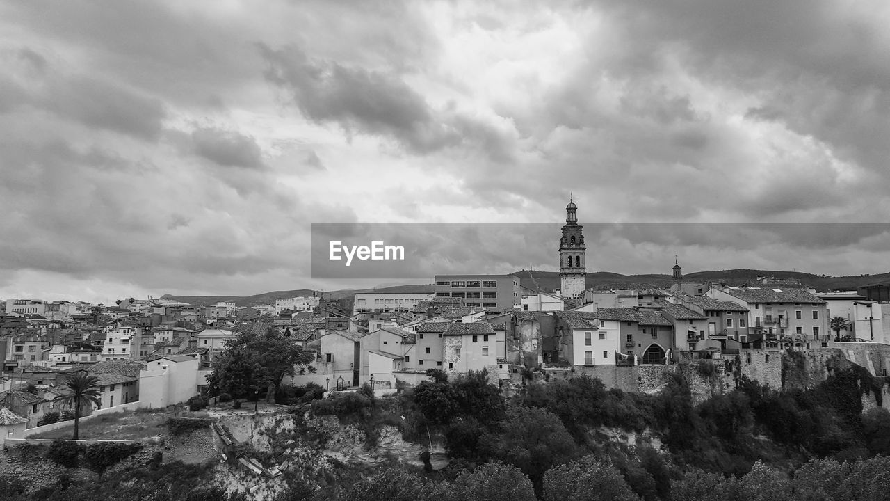 BUILDINGS IN CITY AGAINST CLOUDY SKY