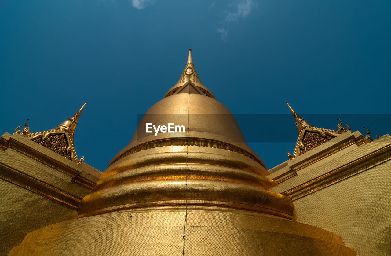 Low angle view of religious structure against blue sky