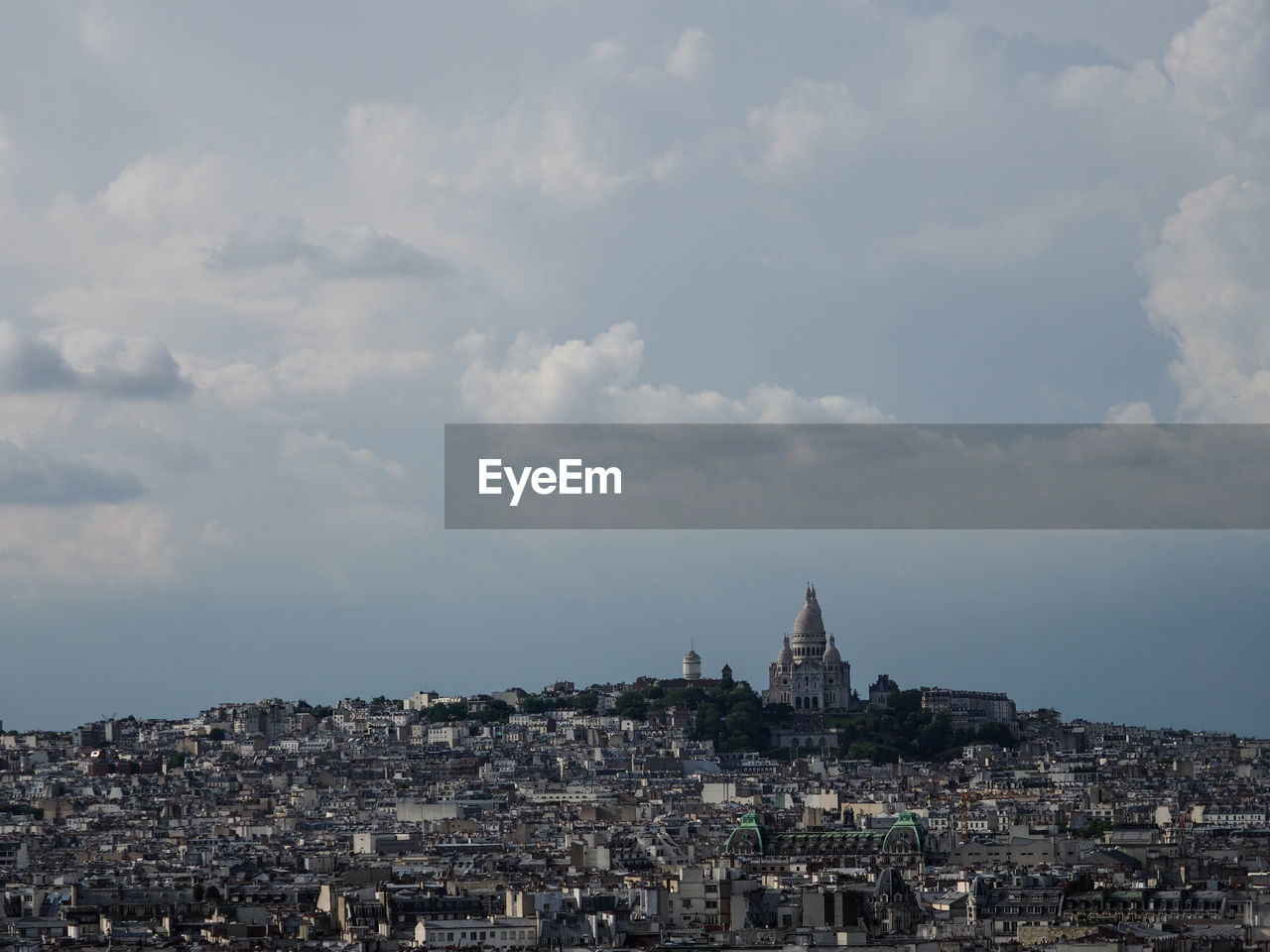 Buildings in city against cloudy sky