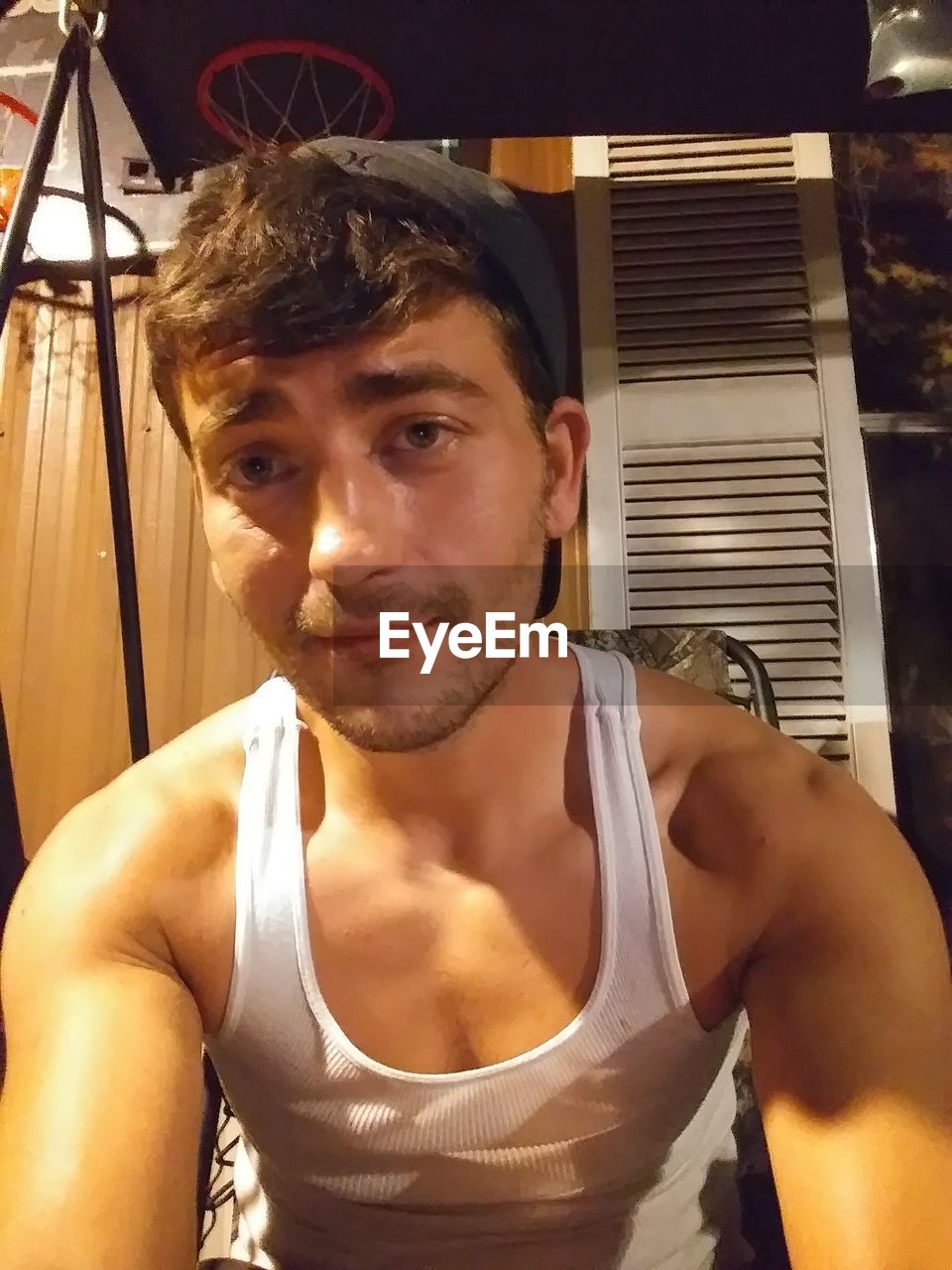 PORTRAIT OF SHIRTLESS YOUNG MAN AT HOME