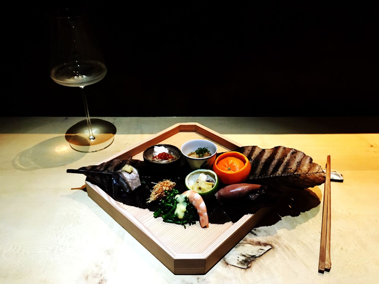 High angle view of fresh seafood and sake on table against black background