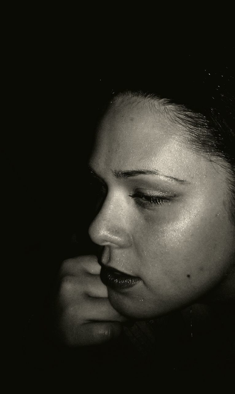 Close-up of woman with make-up in darkroom