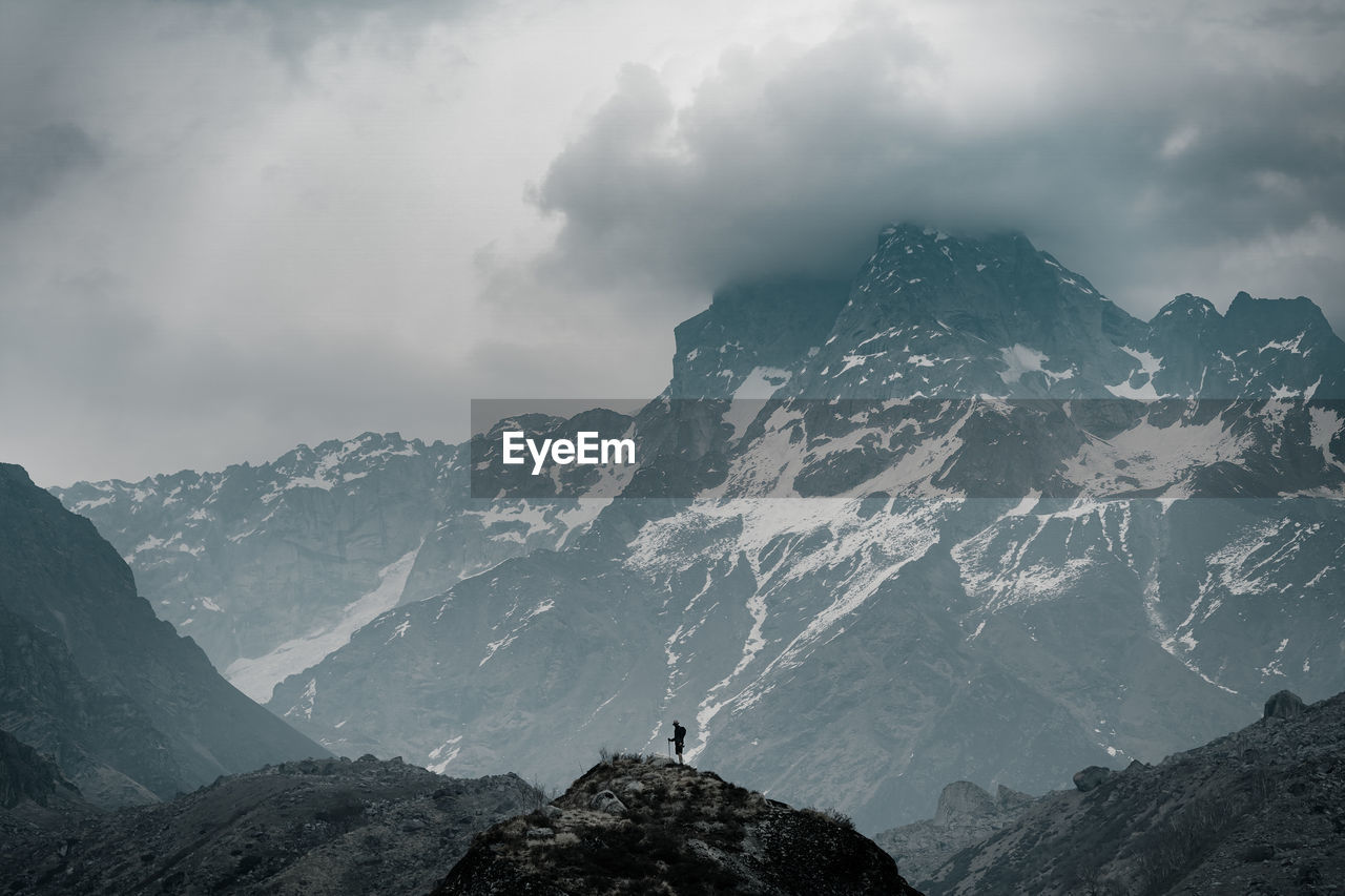 A man looking at huge mountain in front of him