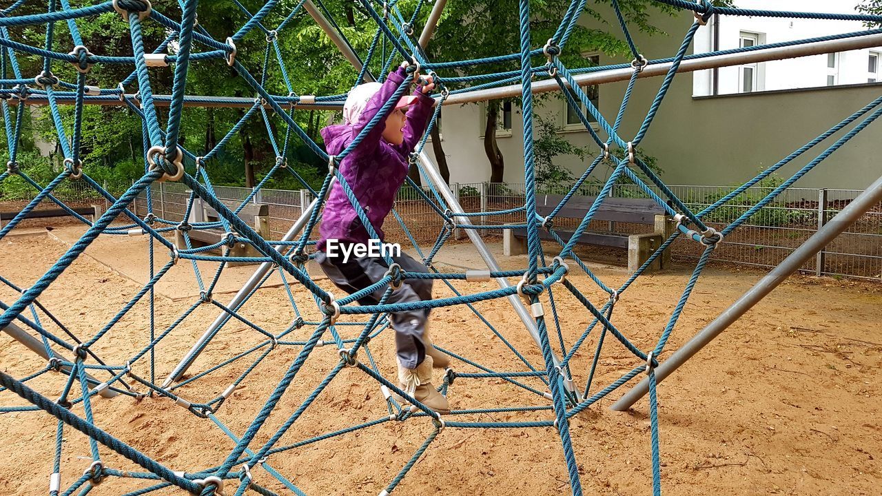 Full length of girl playing on jungle gym at playground