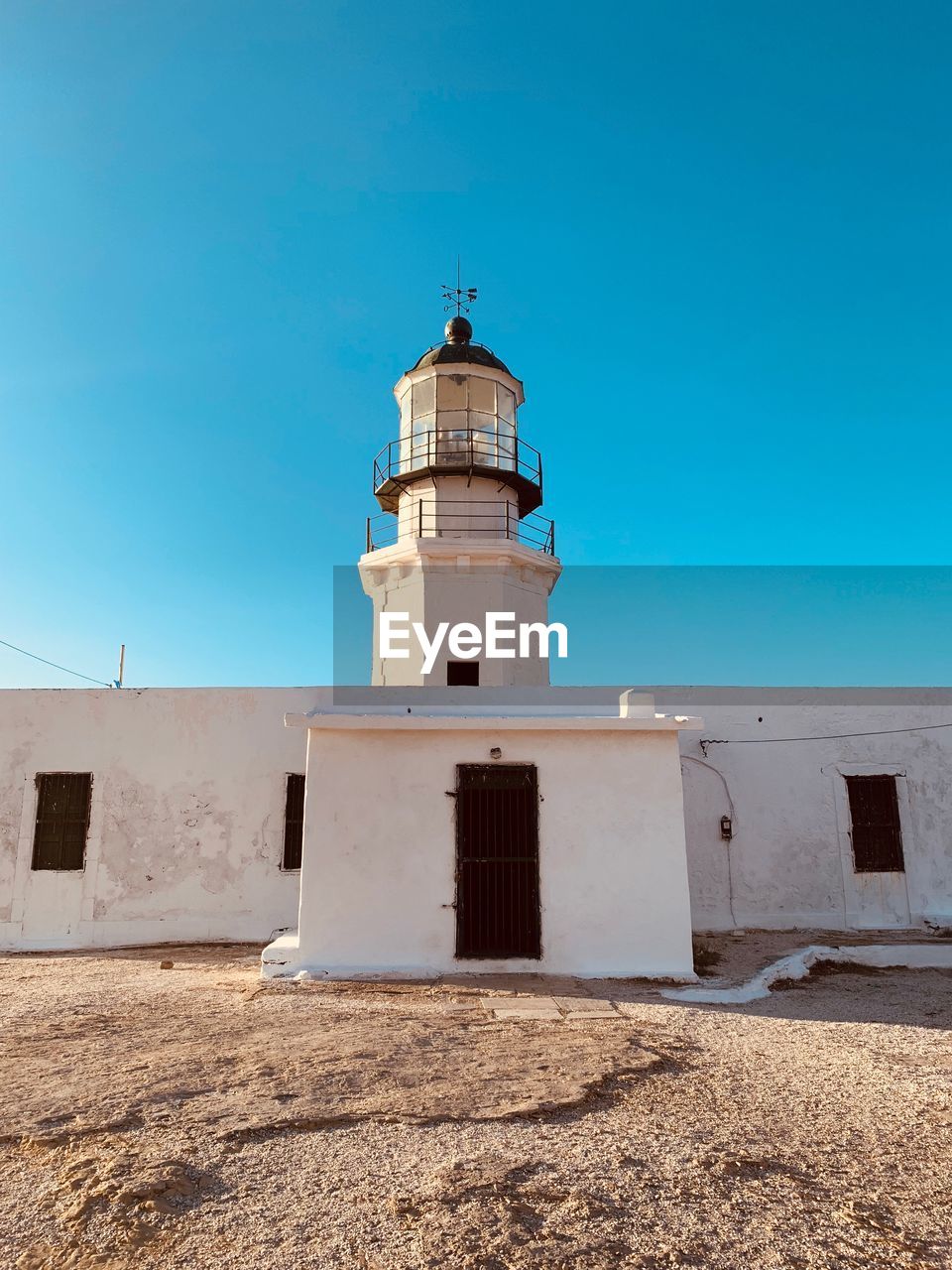 Low angle view of lighthouse against clear blue sky