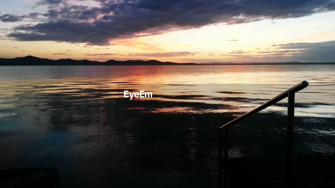 SCENIC VIEW OF BEACH AGAINST DRAMATIC SKY