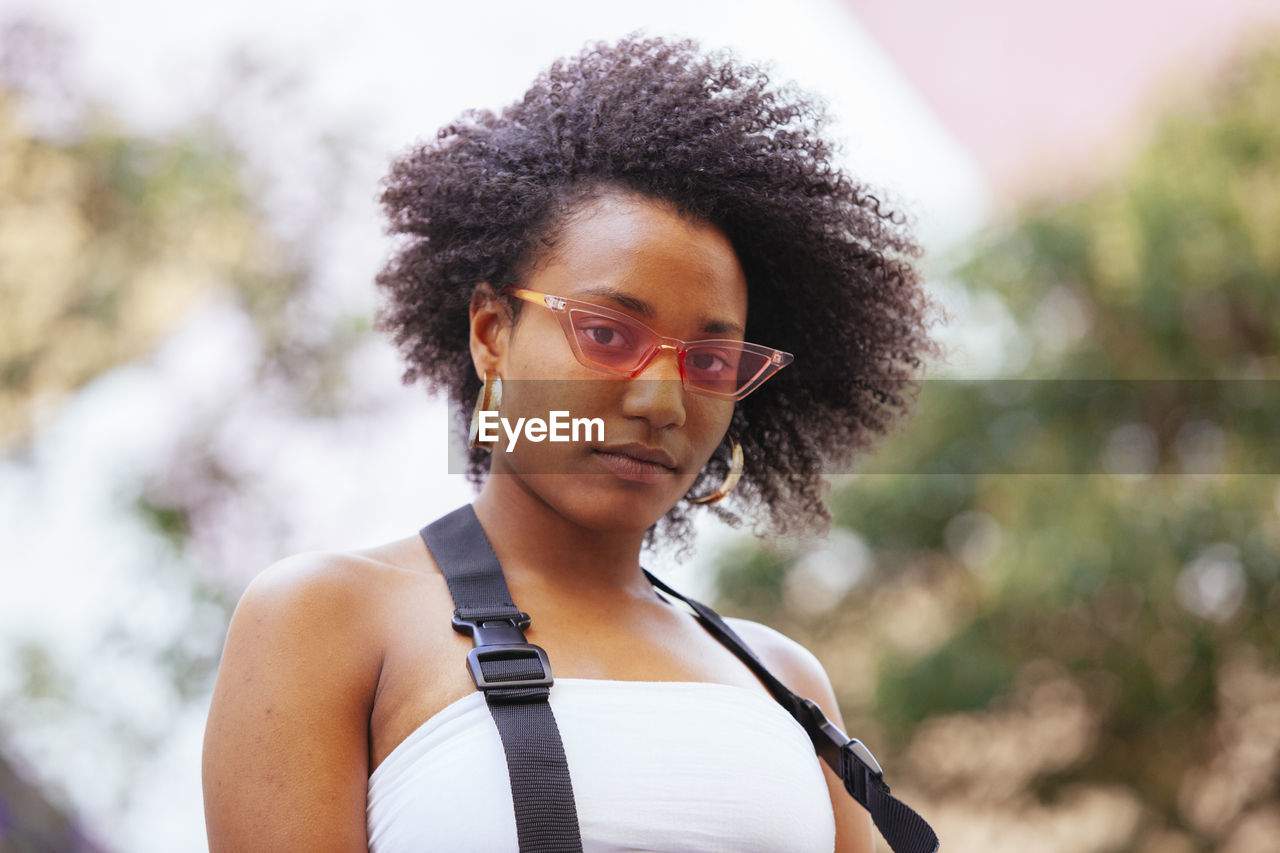 Portrait of young woman wearing sunglasses standing outdoors