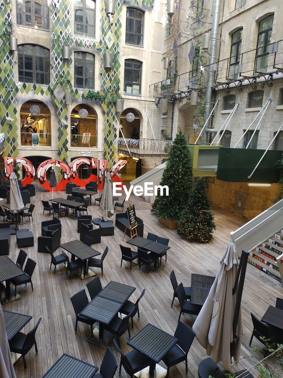 HIGH ANGLE VIEW OF CHAIRS AND TABLE AGAINST BUILDING