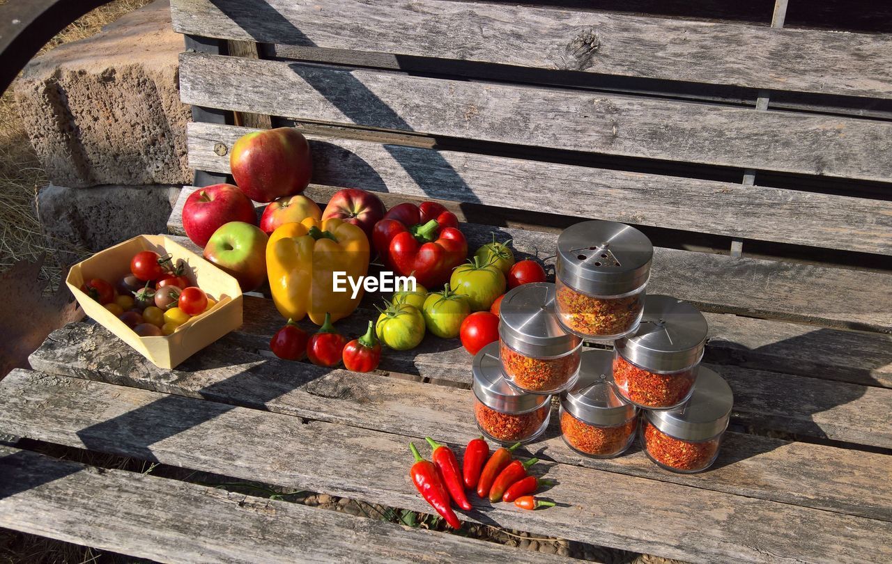 HIGH ANGLE VIEW OF FRUITS IN CONTAINER ON WOODEN TABLE