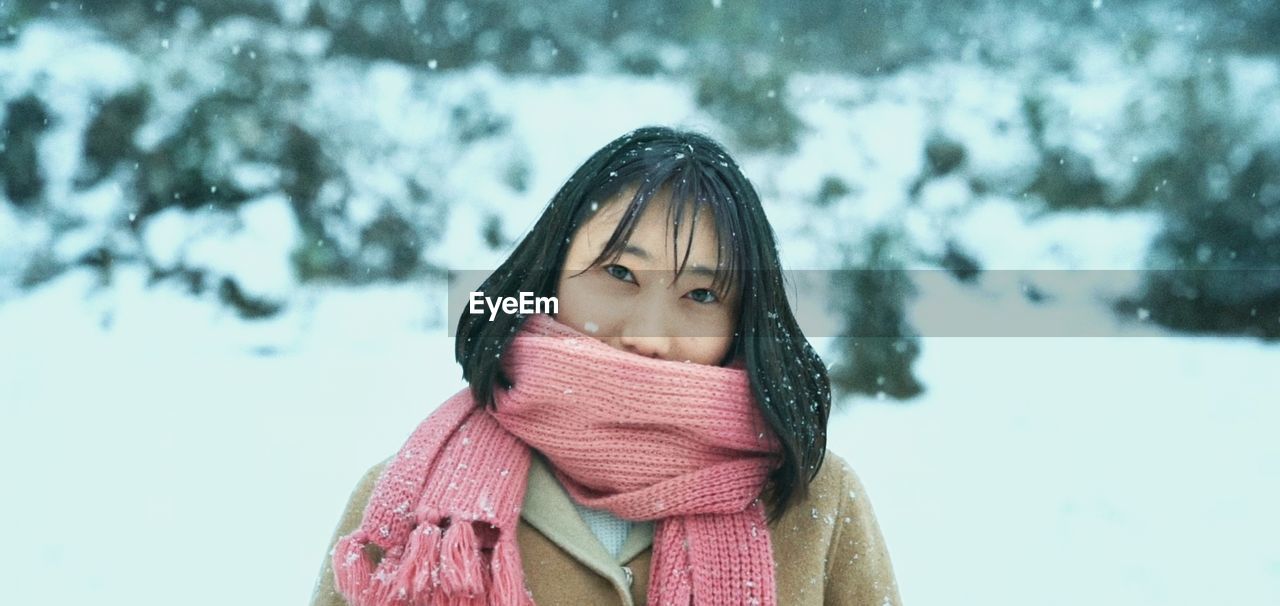 Portrait of woman with scarf on face in snow