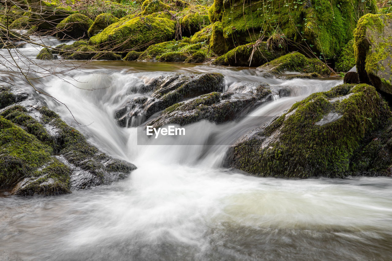 Long exposure of a waterfall flowing over rocks at watersmeet in exmoor national park