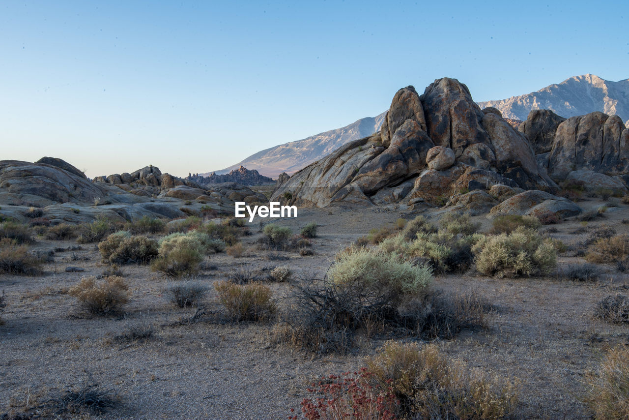 Scenic view of arid desert rock formations in landscape against clear sky