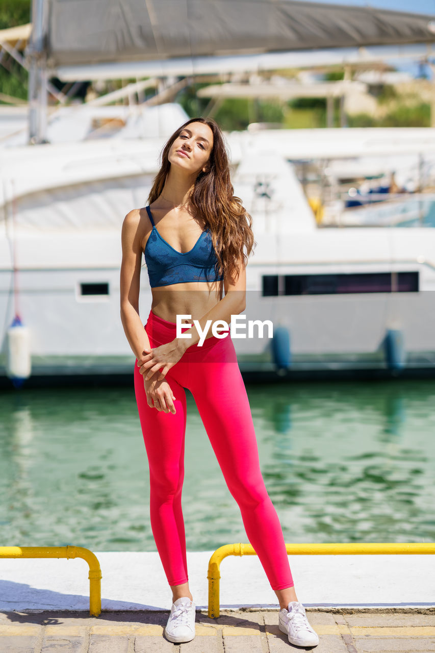 Full length portrait of woman standing at harbor