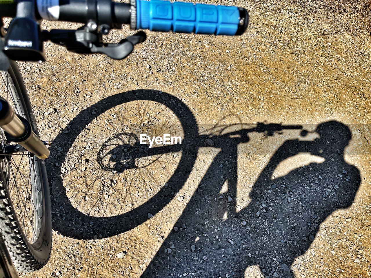 bicycle, transportation, sunlight, shadow, mountain bike, day, land vehicle, vehicle, mode of transportation, road, city, cycle sport, nature, bmx bike, outdoors, high angle view, street, no people, bicycle motocross, cycling, tarmac, communication, sports equipment