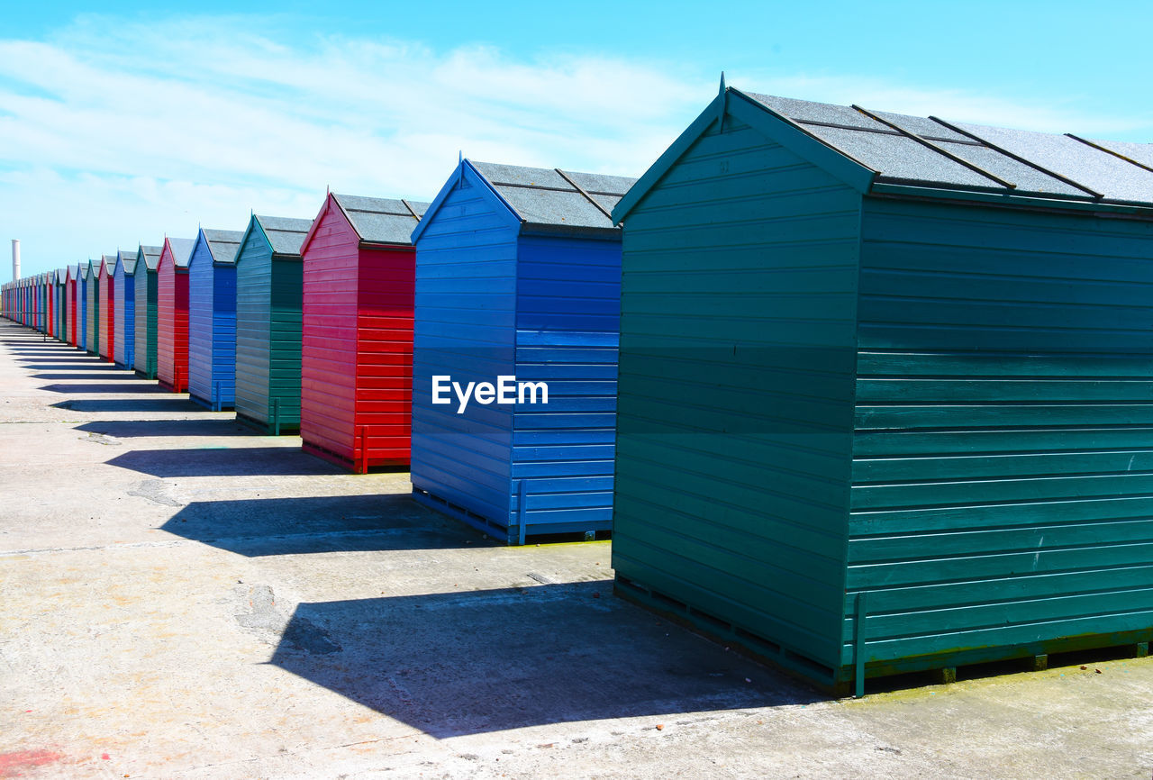 BEACH HUTS AGAINST BUILDINGS AGAINST SKY