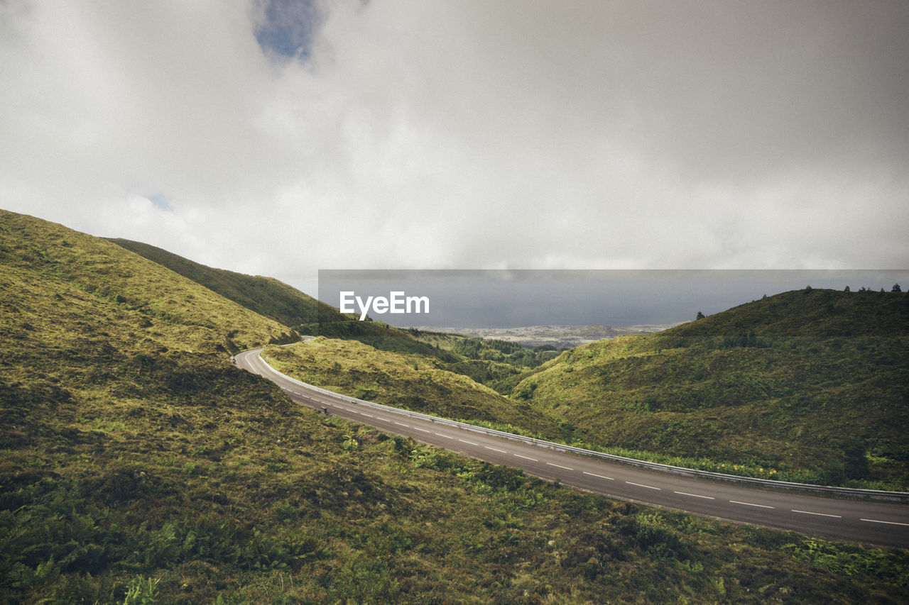 Road leading towards mountains against sky