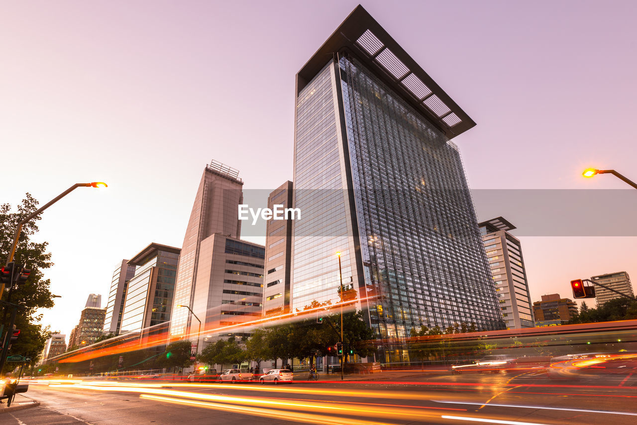 LIGHT TRAILS ON ROAD AGAINST BUILDINGS