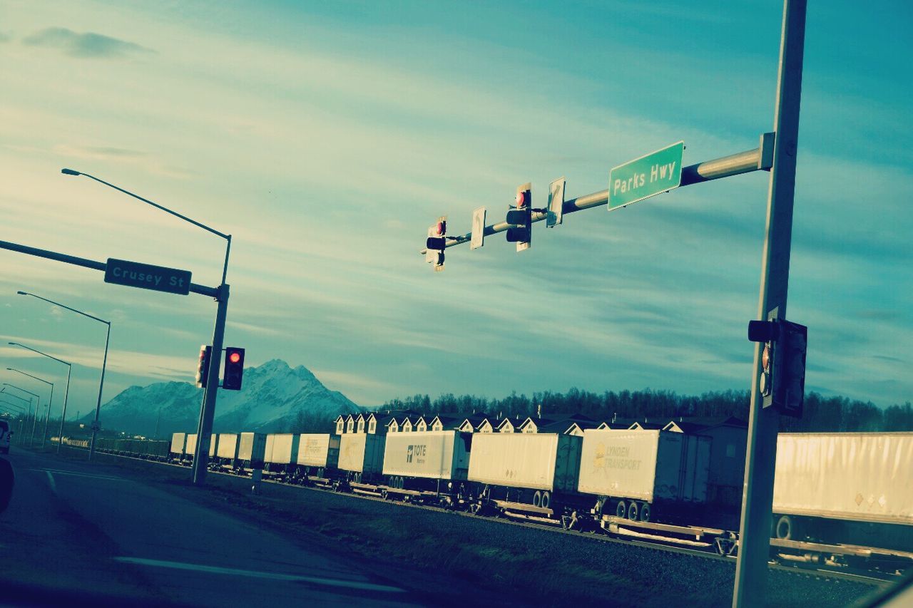 Empty road by trailers against sky