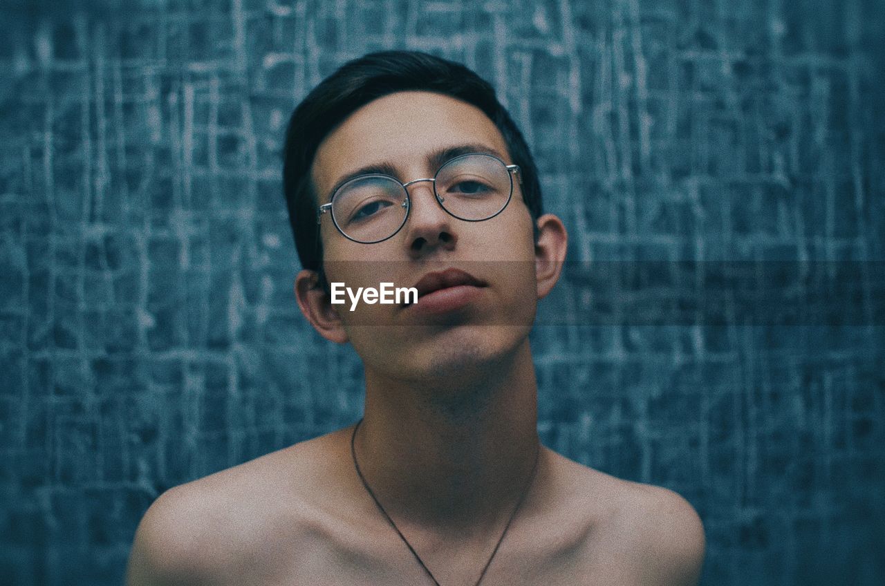 Portrait of handsome young man against wall