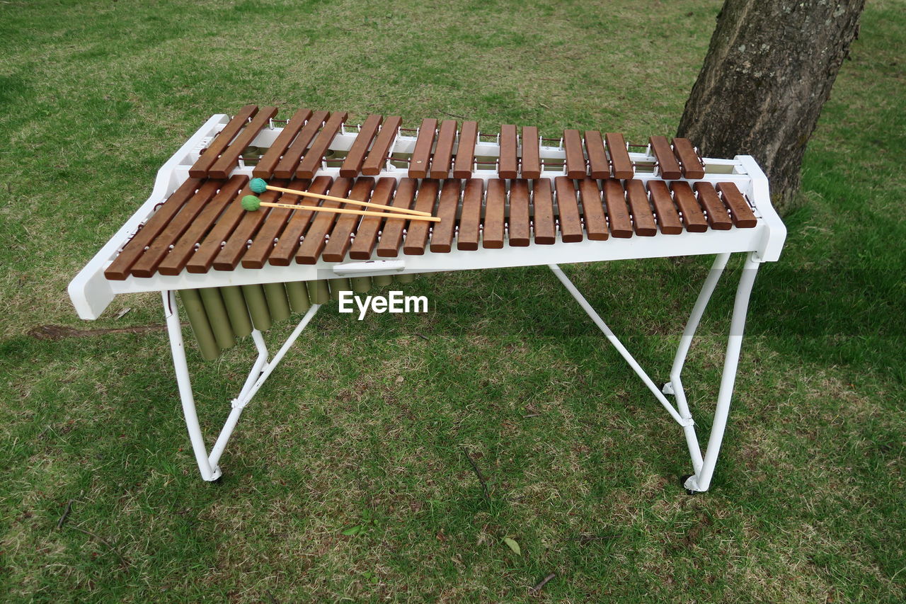 HIGH ANGLE VIEW OF EMPTY BENCH IN FIELD