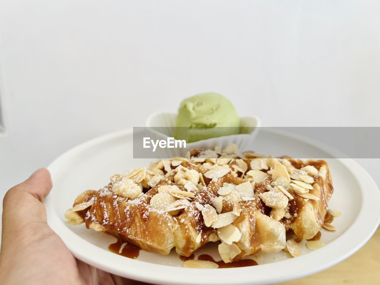 food, food and drink, dish, meal, breakfast, healthy eating, vegetarian food, hand, fruit, produce, freshness, indoors, one person, sweet food, wellbeing, cuisine, plate, dessert, nut, nut - food, lifestyles, sweet, muesli, snack, bowl, studio shot, almond, breakfast cereal, personal perspective, raisin, dairy