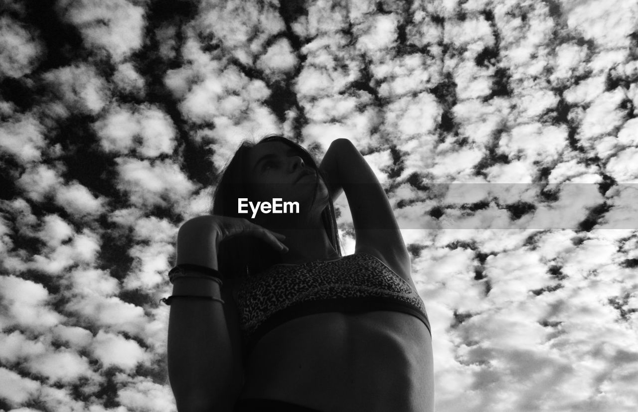 Low angle portrait of woman against sky