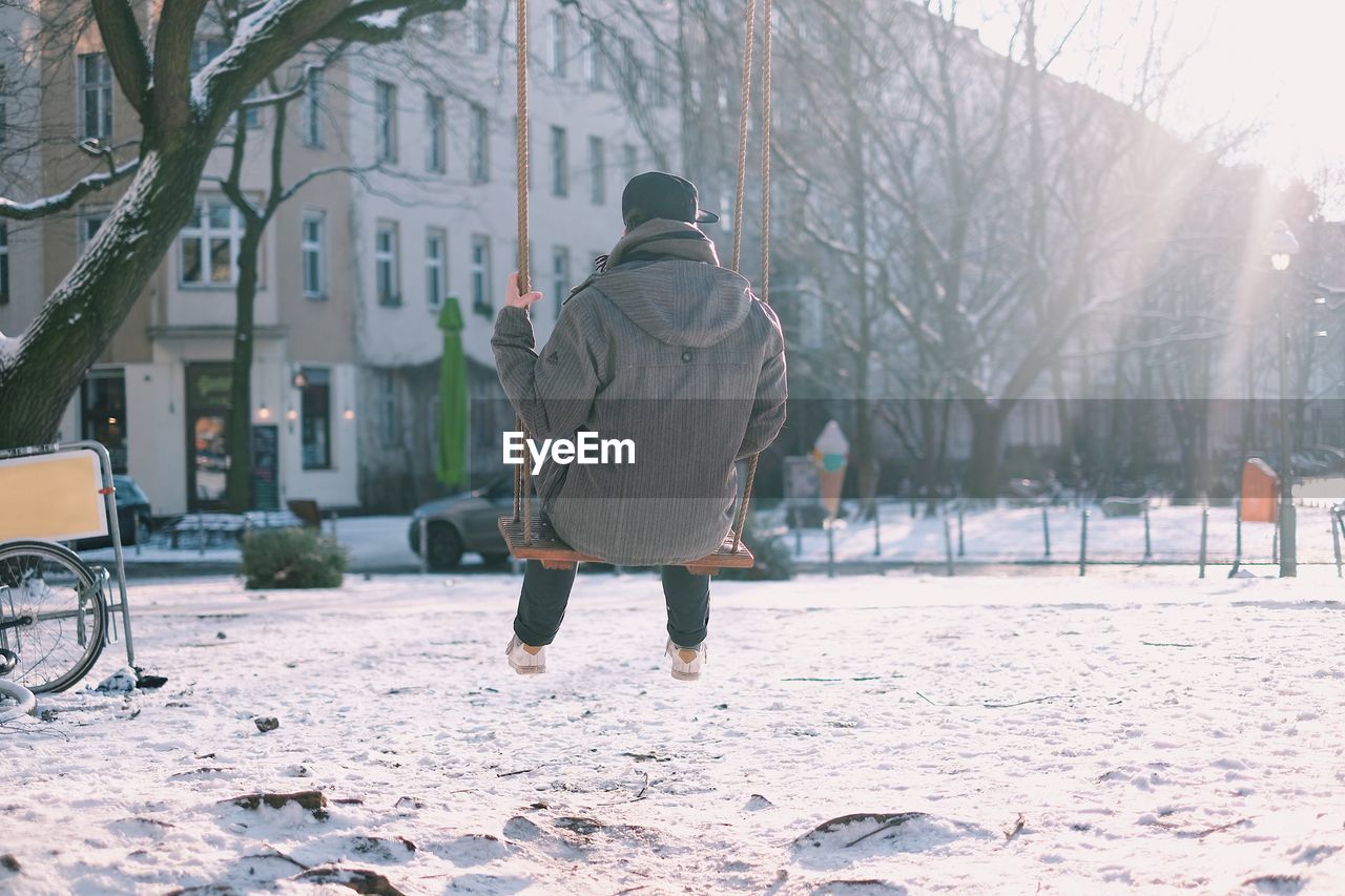 Rear view of man on swing