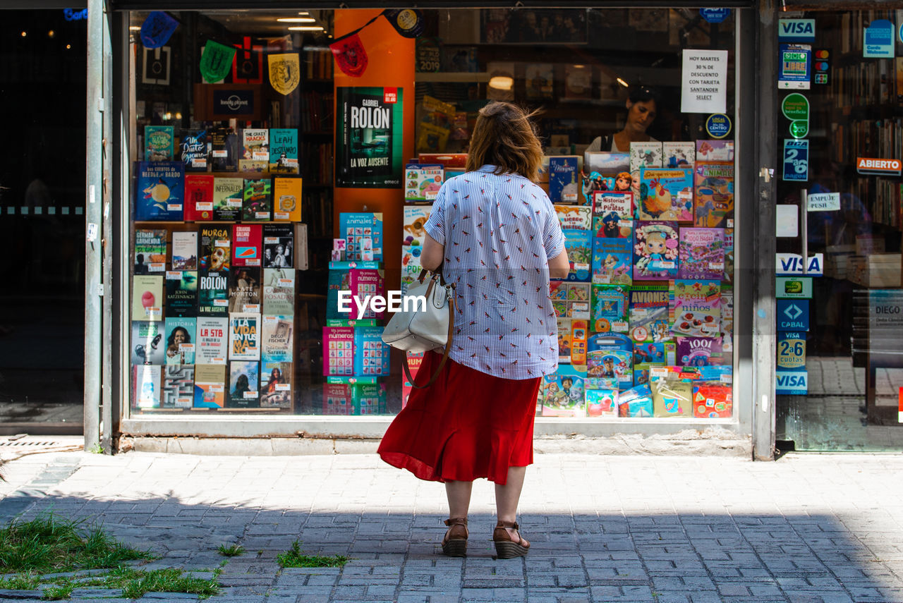 FULL LENGTH REAR VIEW OF WOMAN WALKING ON STREET