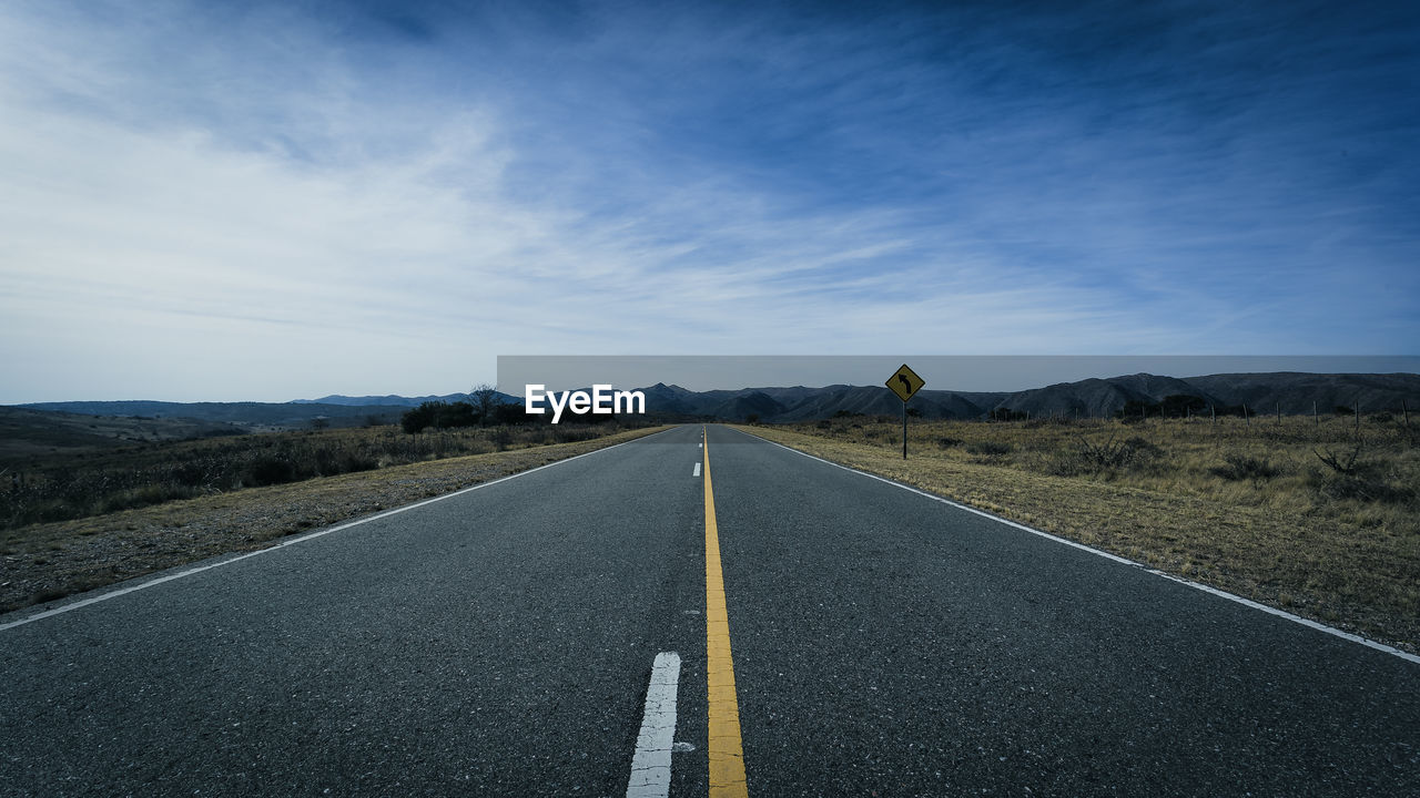 EMPTY ROAD ALONG COUNTRYSIDE LANDSCAPE