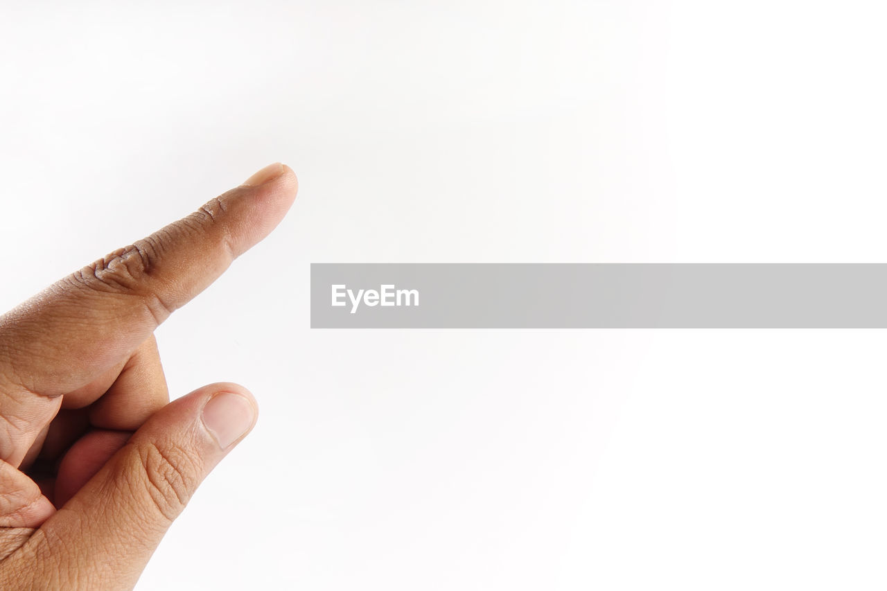 Close-up of human hand gesturing against white background