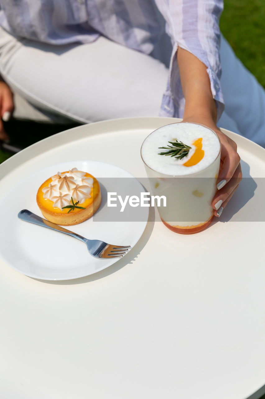 midsection of woman having food on table