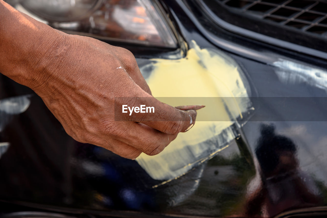 CLOSE-UP OF HAND WORKING ON CAR