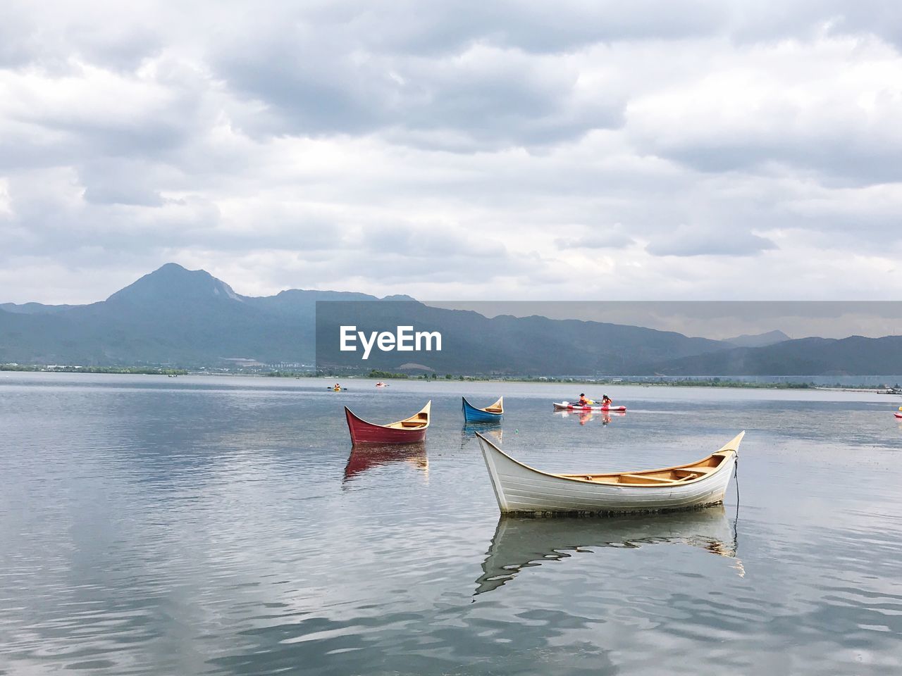 BOAT MOORED ON SHORE AGAINST SKY