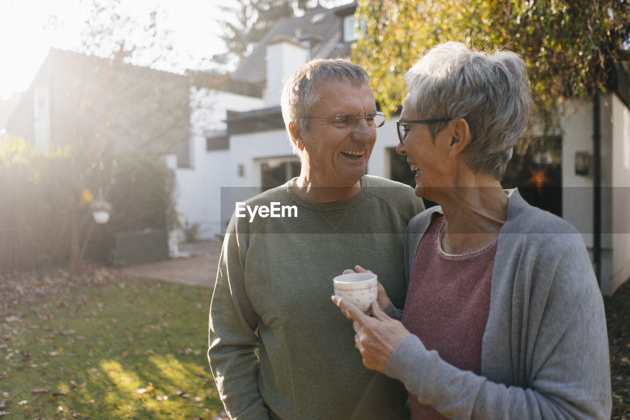 Happy senior couple with cup of coffee in garden