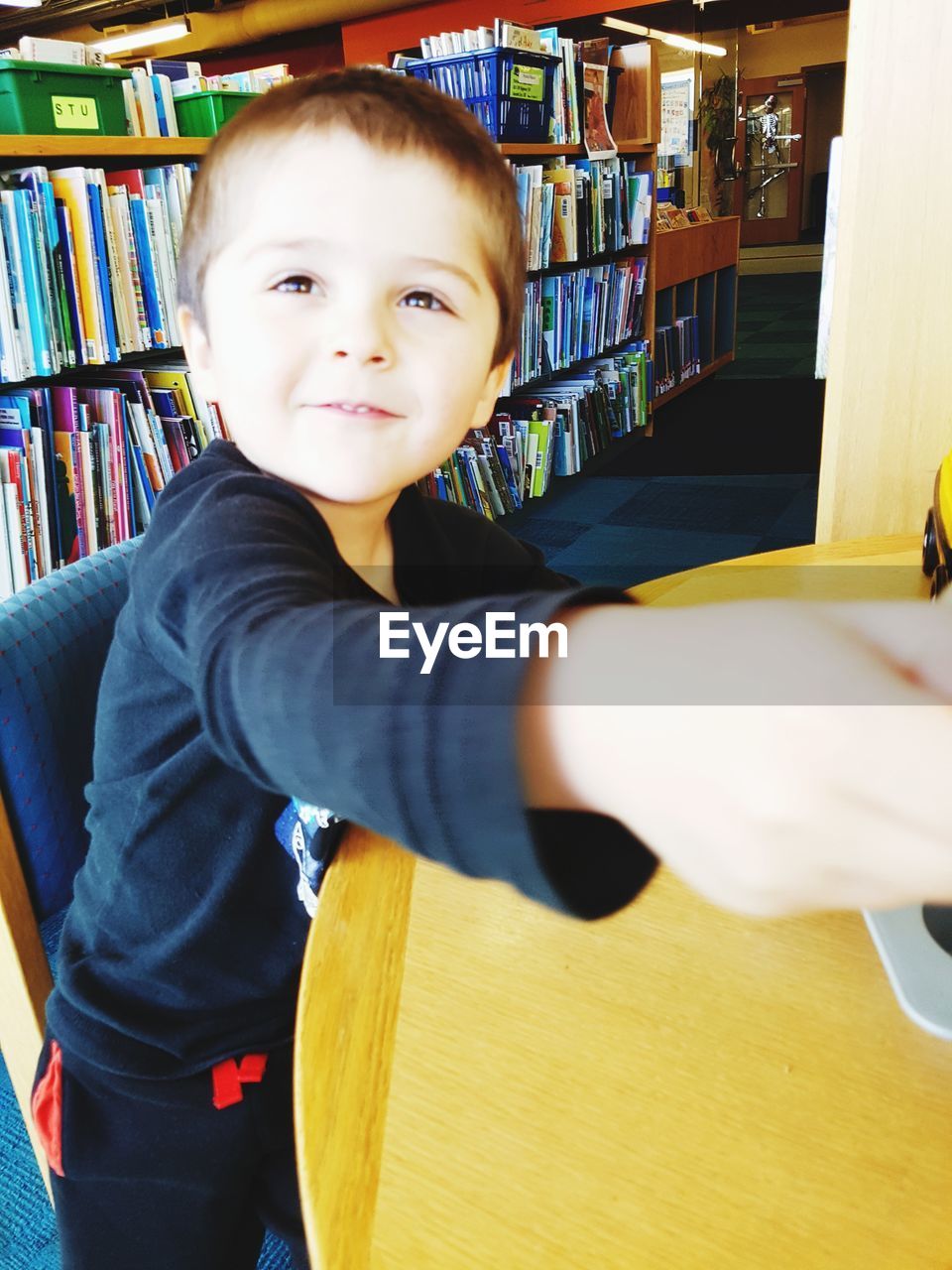 PORTRAIT OF SMILING BOY WITH BOOK