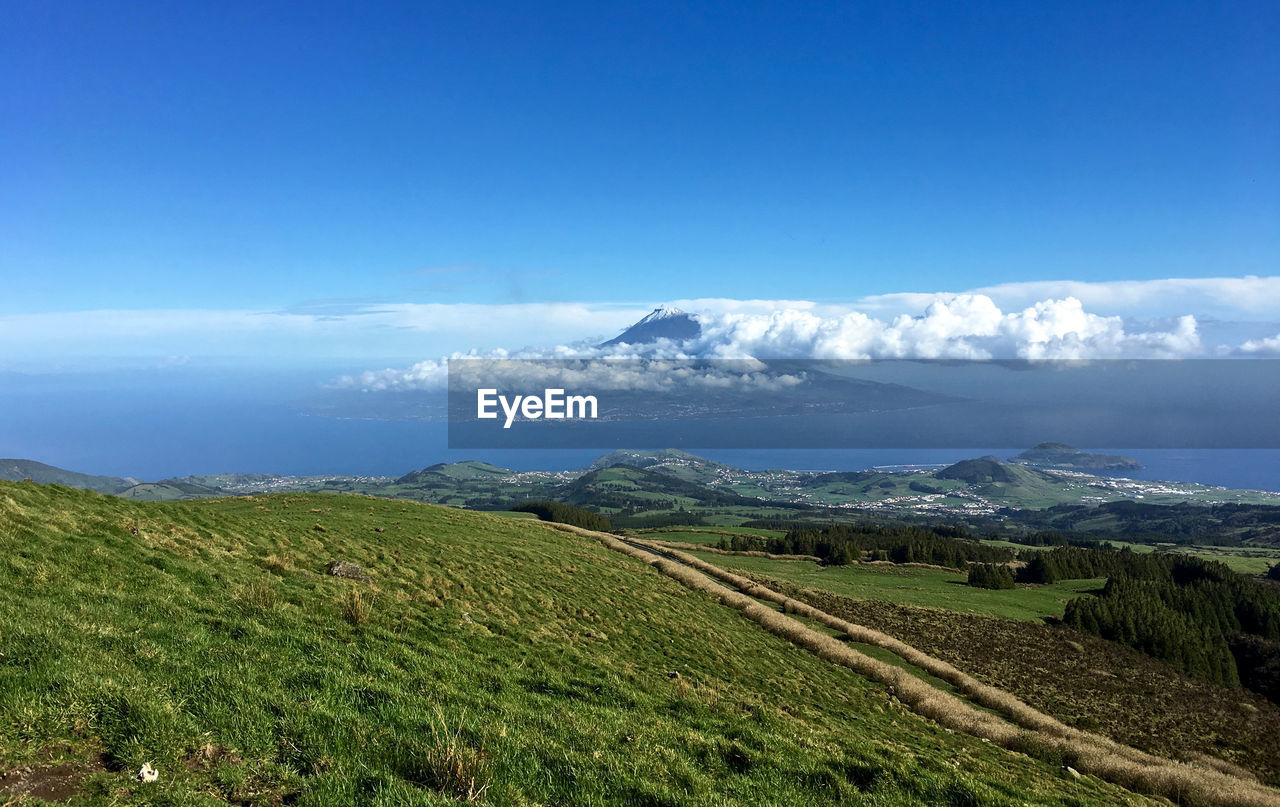 Scenic view of mountains and sea against blue sky