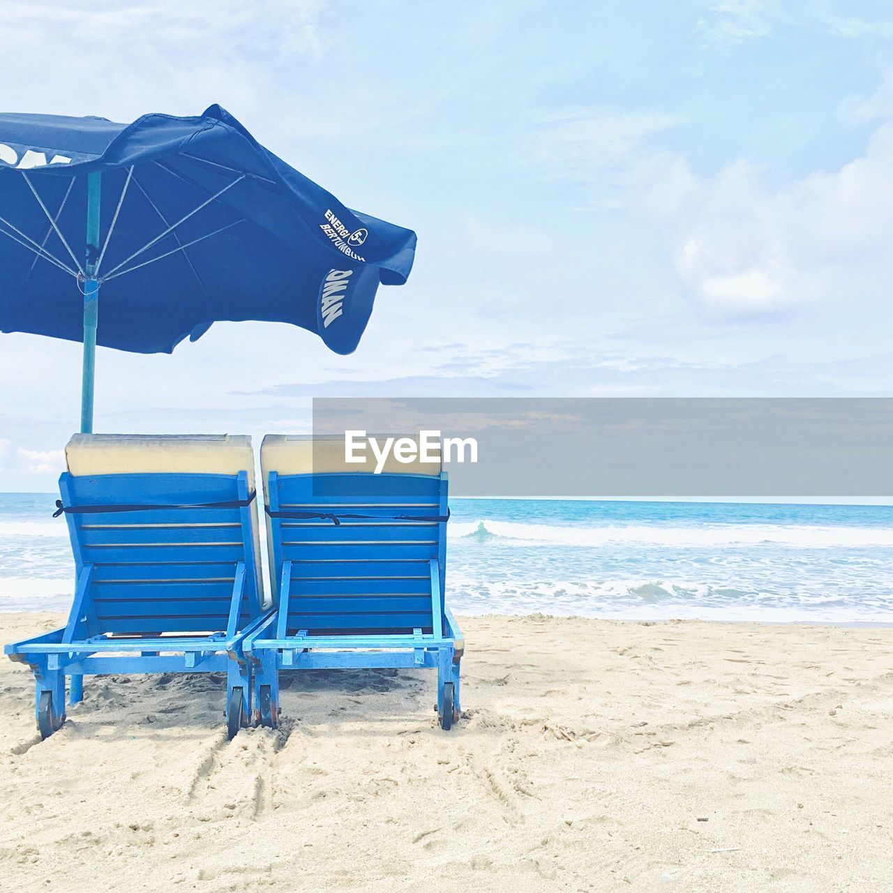 Lounge chairs on beach against sky