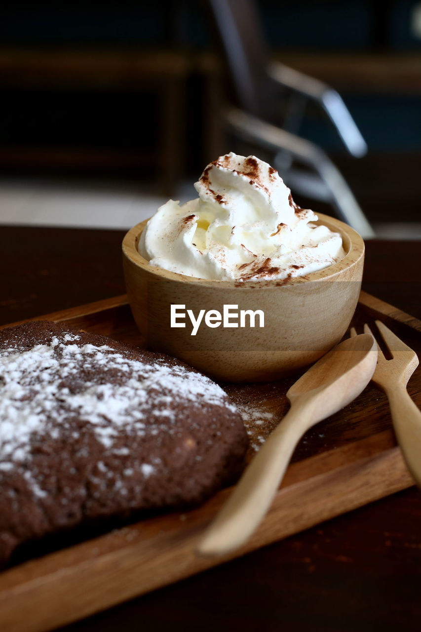 CLOSE-UP OF ICE CREAM ON WOODEN TABLE