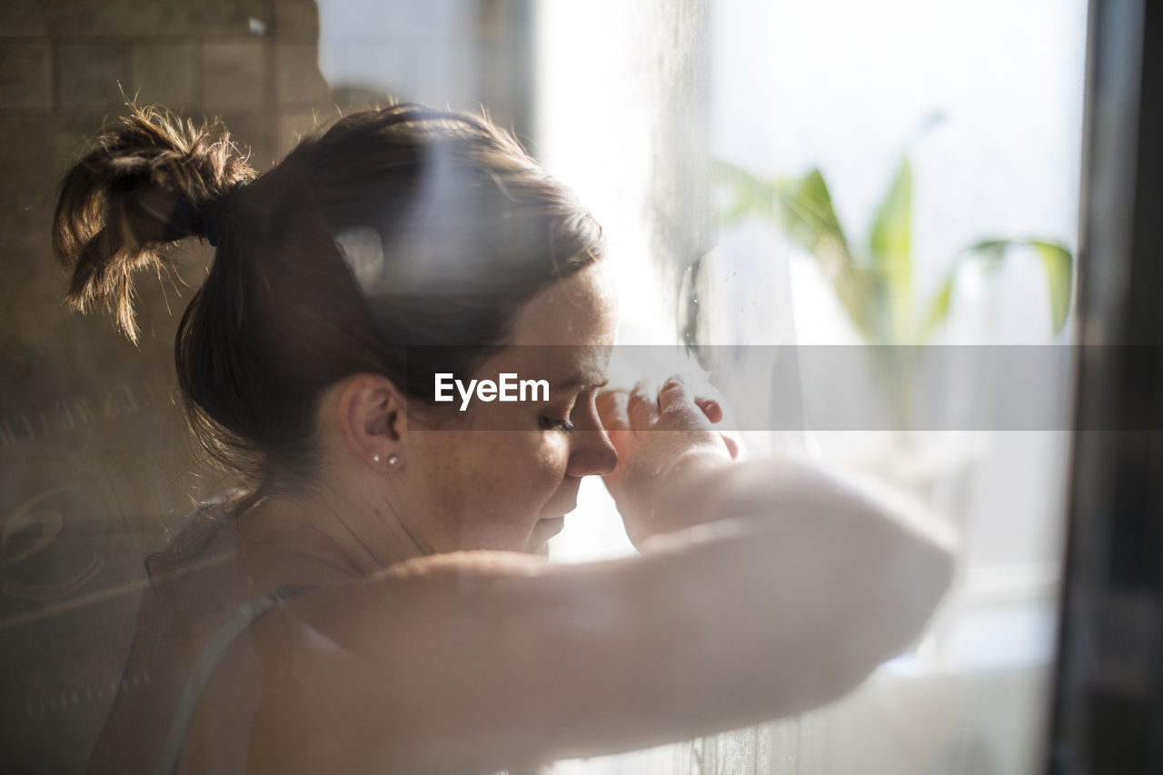 Side view of pregnant woman in labor at home by window