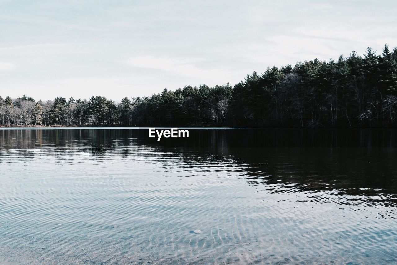 Scenic view of calm lake against cloudy sky