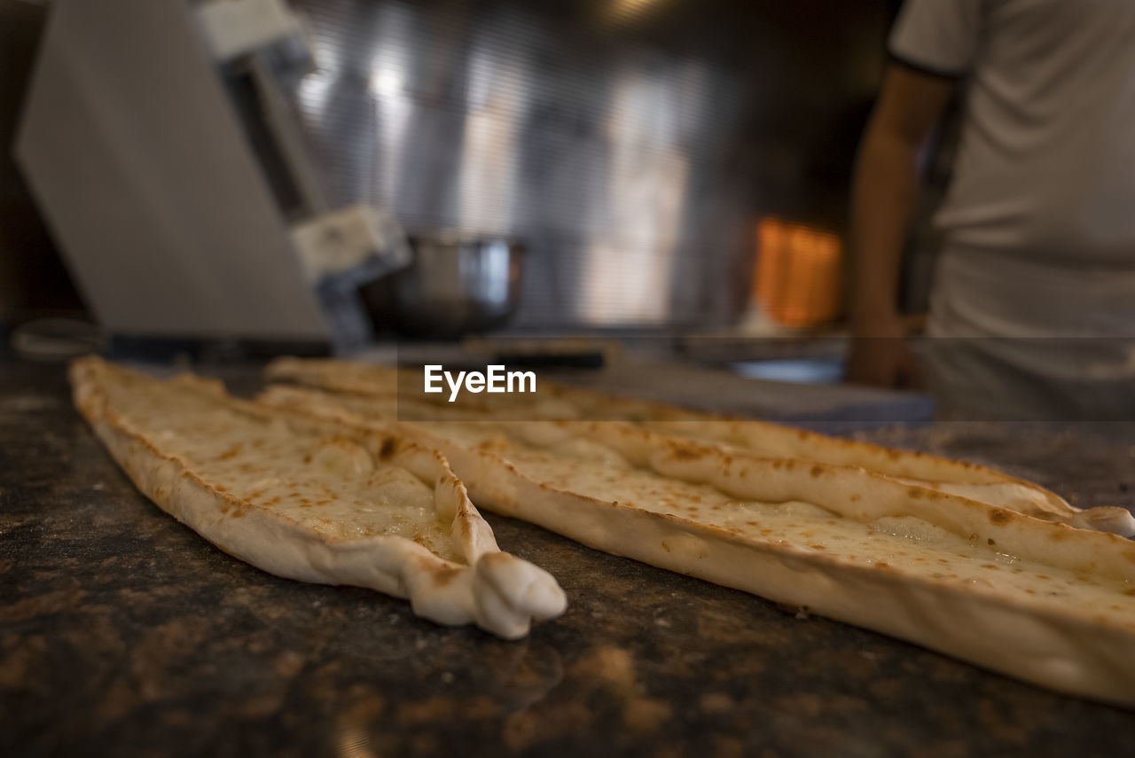 Turkish pide with cheese on counter at restaurant