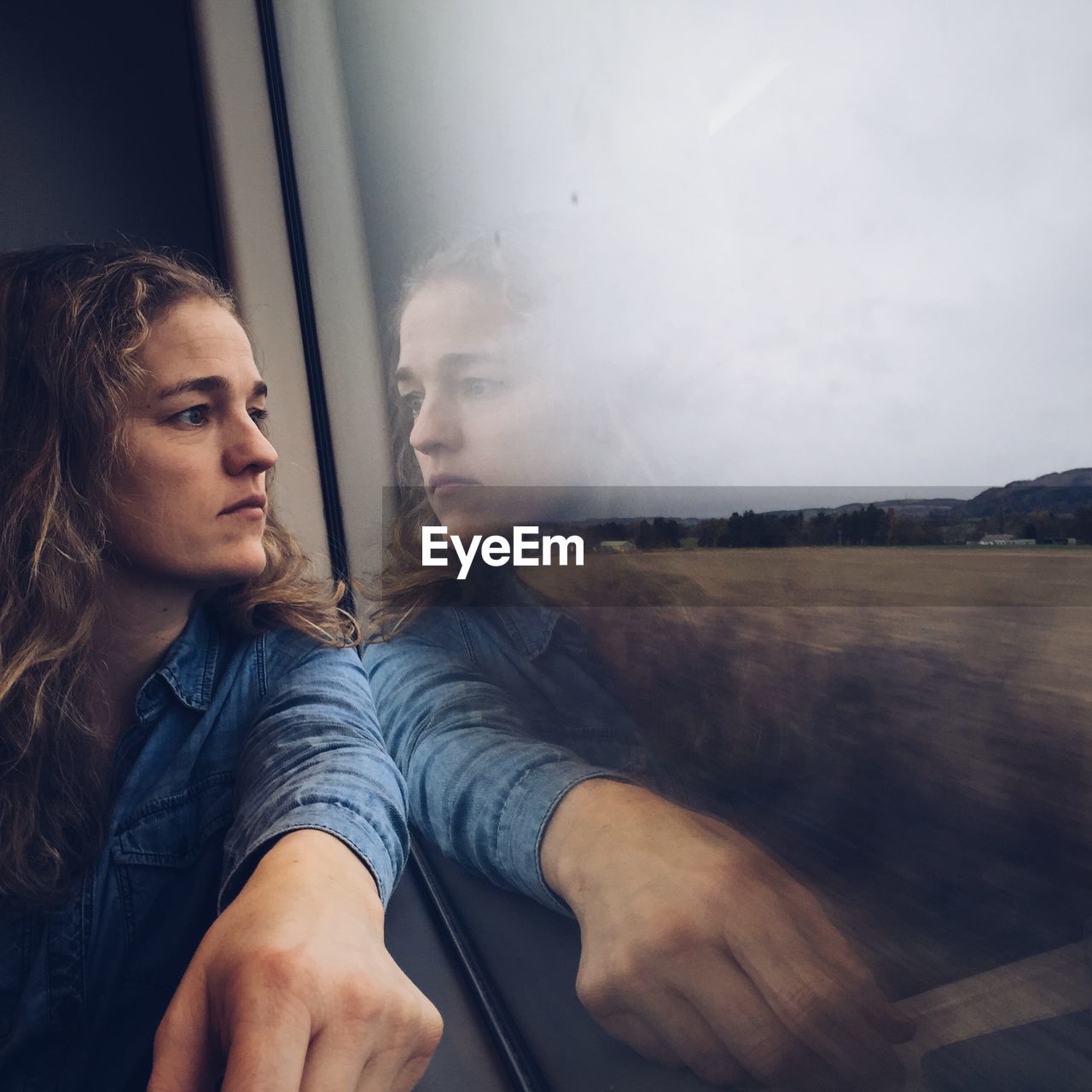Woman looking through window on train