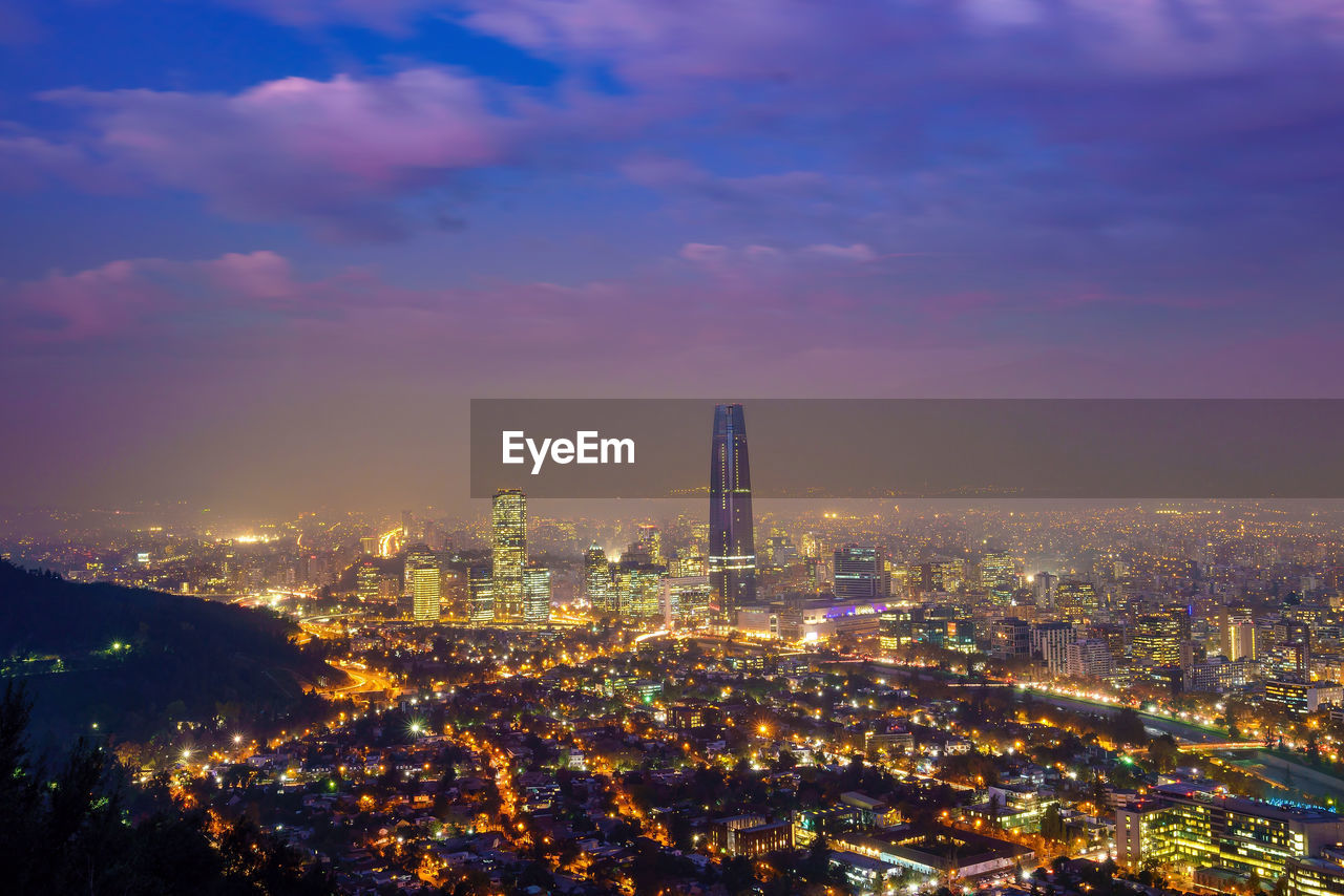 aerial view of illuminated cityscape against sky at night