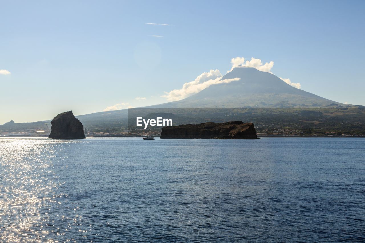 Scenic view of sea and mountains against sky